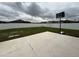 Fenced backyard with a basketball hoop, ample green space, and a concrete patio at 8835 Conway Rd, Polk City, FL 33868