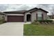 Charming single-story home with a well-manicured lawn, dark brown garage door, and neutral exterior paint at 8835 Conway Rd, Polk City, FL 33868