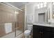 Well-lit bathroom with a glass shower, granite countertop, and dark wood cabinetry at 8960 Adriatico Ln, Kissimmee, FL 34747