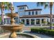 A fountain in front of the impressive clubhouse with a stucco exterior and clay tile roof at 8960 Adriatico Ln, Kissimmee, FL 34747