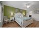 A cozy main bedroom features botanical decor, wood floors, and a ceiling fan at 8960 Adriatico Ln, Kissimmee, FL 34747