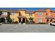 Charming townhome exterior featuring colorful paint, tile roof, and assigned parking spaces at 8961 California Palm Rd, Kissimmee, FL 34747