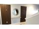 Hallway featuring decorative paneling, a stylish mirror, and modern sconce lighting at 8961 California Palm Rd, Kissimmee, FL 34747