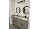 Bathroom with gray cabinets, double sinks, and modern fixtures at 915 Alsace Dr, Kissimmee, FL 34759