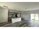 Bright kitchen with gray cabinets, stainless steel appliances, granite countertops, and sliding glass doors to the backyard at 915 Alsace Dr, Kissimmee, FL 34759