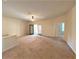 Spacious carpeted living room with a ceiling fan, neutral colors, and access to the balcony at 1001 Via Santae Ln # 201, Celebration, FL 34747