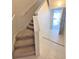 Carpeted stairway leading up to the next level with natural light and neutral decor at 1001 Via Santae Ln # 201, Celebration, FL 34747