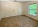 Neutral bedroom featuring plush carpeting, a window, and closet with double doors at 1017 Siena Park E Blvd, Celebration, FL 34747