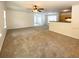 Spacious living room featuring neutral carpet, ceiling fan, and a pass-through to the kitchen area at 1017 Siena Park E Blvd, Celebration, FL 34747