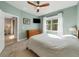 Bedroom with wood ceiling fan, neutral decor, large window with wood dresser, flat screen TV, and bright natural light at 1036 Salamanca Pl, Davenport, FL 33837