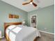 Bedroom with a bright ensuite bathroom view, ceiling fan, neutral decor, and bright natural light at 1036 Salamanca Pl, Davenport, FL 33837