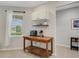 Breakfast nook features a rolling island, white cabinets on the wall, and natural light from the large bright window at 1036 Salamanca Pl, Davenport, FL 33837