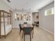 Bright dining room features an oval wood table set with seating for four, modern shelving, and neutral tile floors at 1036 Salamanca Pl, Davenport, FL 33837