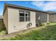 Exterior side-view of a home showing a window, hose and the screened in back patio with garden at 1036 Salamanca Pl, Davenport, FL 33837