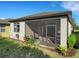 View of the back patio with screened enclosure, exterior plants and an outdoor grill, providing a backyard oasis at 1036 Salamanca Pl, Davenport, FL 33837