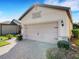 Wide garage door, with a brick paved driveway and manicured landscaping, showcasing the home's curb appeal at 1036 Salamanca Pl, Davenport, FL 33837