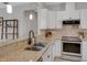 Close up on kitchen features granite countertops, stainless steel appliances, a view to an eat-in space, and white cabinets at 1036 Salamanca Pl, Davenport, FL 33837