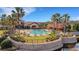 Community resort style pool with tables, chairs, and umbrellas under bright blue skies at 1036 Salamanca Pl, Davenport, FL 33837