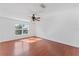 Bright bedroom features wood flooring, a ceiling fan, and a window providing ample natural light at 1067 Ronlin St, Haines City, FL 33844