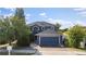 Two-story home featuring a dark blue exterior, well-maintained landscaping, and a paved driveway at 1067 Ronlin St, Haines City, FL 33844