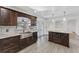 Elegant kitchen with stainless steel sink, dark wood cabinets, and a kitchen island, perfect for entertaining guests at 1067 Ronlin St, Haines City, FL 33844