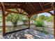 Backyard featuring a wooden pergola with string lights, mature trees, and manicured landscaping at 1067 Ronlin St, Haines City, FL 33844