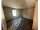 Bedroom with durable wood-look floors, white walls, and a view of the outdoors through a window at 11776 Nw 18Th Pl, Ocala, FL 34482