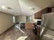 Open kitchen featuring stainless steel refrigerator, wood cabinets, black appliances and durable wood-look floors at 11776 Nw 18Th Pl, Ocala, FL 34482