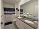 Bathroom featuring a granite countertop with double sinks, modern mirror, and shower with dark-colored curtain at 1292 Cascades Ave, Davenport, FL 33837