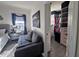 Cozy bedroom with a gray sofa, leading to a walk-in closet with custom shelving at 1292 Cascades Ave, Davenport, FL 33837