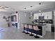 Modern island kitchen with bar stool seating and stainless steel appliances overlooks the living room and fireplace at 1292 Cascades Ave, Davenport, FL 33837