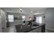 Kitchen with gray countertops, modern fixtures, island seating and view into the living room at 1292 Cascades Ave, Davenport, FL 33837