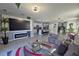 Spacious living room featuring a fireplace, large TV, and comfortable seating, transitioning to an island kitchen at 1292 Cascades Ave, Davenport, FL 33837