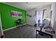 Bright home office featuring a vibrant green wall, modern desk setup, and ample natural light at 1292 Cascades Ave, Davenport, FL 33837