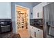 Well-stocked pantry with ample shelving, adjacent to kitchen with stainless steel refrigerator and granite counters at 1292 Cascades Ave, Davenport, FL 33837