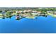 Scenic aerial shot of a community lake featuring a dock and a clubhouse with a pool at 142 Magellan Ct, Davenport, FL 33837