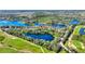 Scenic aerial view of a home near a golf course, surrounded by serene lakes and lush greenery at 142 Magellan Ct, Davenport, FL 33837