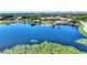 Picturesque lake view showcasing a gazebo, dock, and the community clubhouse with a pool at 142 Magellan Ct, Davenport, FL 33837