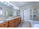 Elegant bathroom with double sinks, granite countertops, and a tiled walk-in shower at 142 Magellan Ct, Davenport, FL 33837