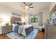 Comfortable bedroom featuring stylish decor, a ceiling fan, and natural light from a large window at 142 Magellan Ct, Davenport, FL 33837