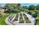 Elevated garden beds in a fenced community garden with various plants and gravel pathways at 142 Magellan Ct, Davenport, FL 33837