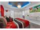 Cozy bedroom with a vibrant red and grey bed, complemented by a decorative ceiling and themed TV at 1520 Oak Hill Trl, Kissimmee, FL 34747