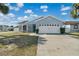 Front exterior of a well-maintained house with a two-car garage and a manicured lawn at 1520 Oak Hill Trl, Kissimmee, FL 34747