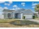 Charming single-story home with light blue siding, well-maintained lawn, and a two-car garage at 1520 Oak Hill Trl, Kissimmee, FL 34747