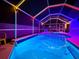 Swimming pool and spa illuminated with vibrant LED lighting within the screened lanai, perfect for nighttime relaxation at 1520 Oak Hill Trl, Kissimmee, FL 34747