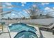 Gorgeous swimming pool with an attached spa, surrounded by a screened enclosure and comfortable lounge chairs at 1520 Oak Hill Trl, Kissimmee, FL 34747