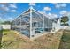 Wide backyard view of the swimming pool and jacuzzi encased in a large screened lanai, perfect for relaxation at 1520 Oak Hill Trl, Kissimmee, FL 34747