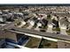 An aerial view shows a residential neighborhood with varied home styles, sidewalks, and fenced backyards at 1567 Dawnview Way, Kissimmee, FL 34744