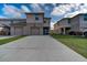 Shows the rear exterior of a two-story townhome with long driveway and two-car garage at 1567 Dawnview Way, Kissimmee, FL 34744