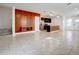 Expansive living room featuring tile floors, a sleek wooden accent wall, and an open layout leading to the kitchen at 1567 Dawnview Way, Kissimmee, FL 34744